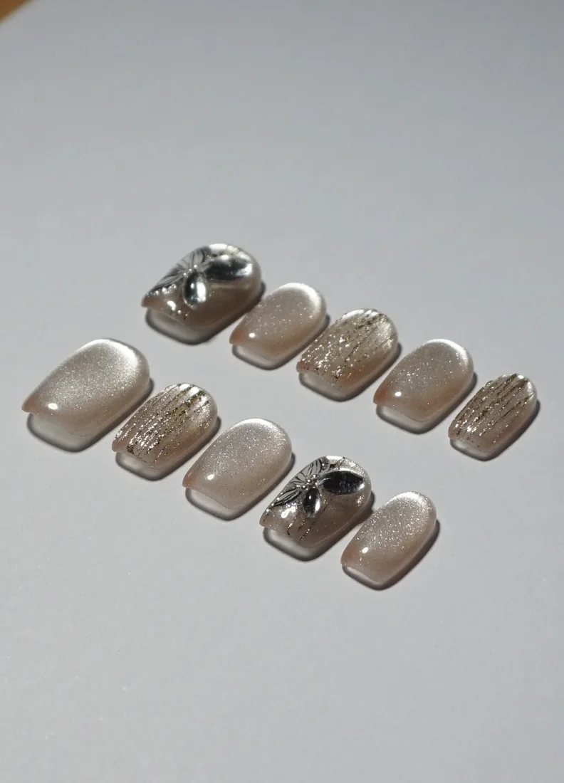 Blanc pailleté a motif papillon - press on nails disponibles chez Moon & Star